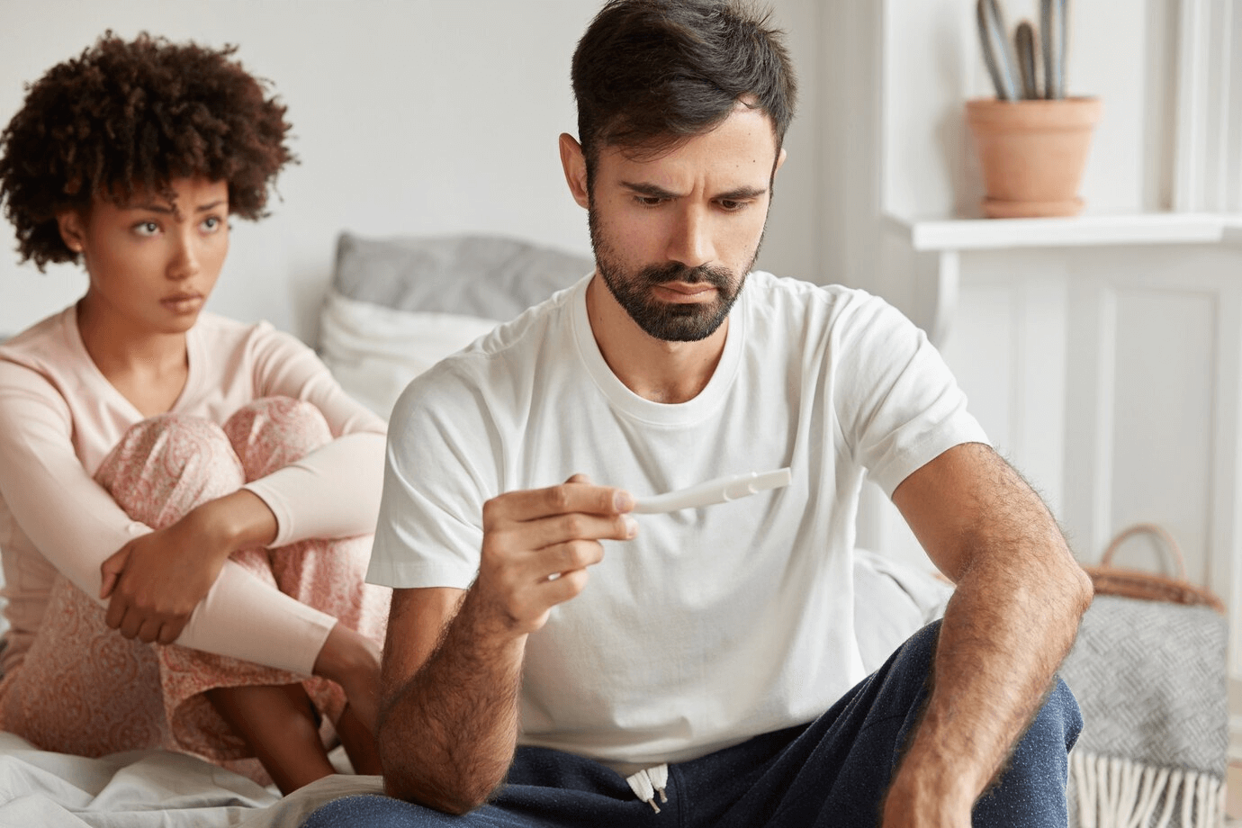 casal com teste de gravidez em mãos e tentando descobrir causas de infertilidade